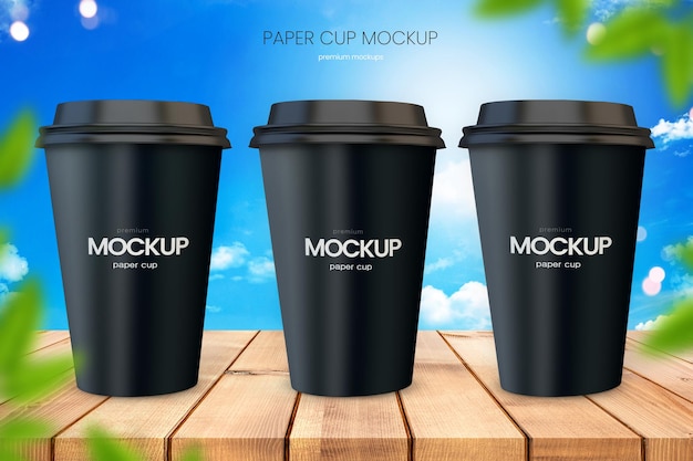 Paper coffee cup mockup of three cups on wooden tabletop with bright blue sky in background