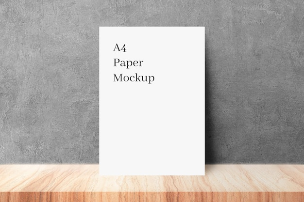 PSD paper mockup on wood with grey wall texture background