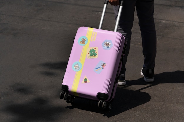 Person carrying luggage with stickers