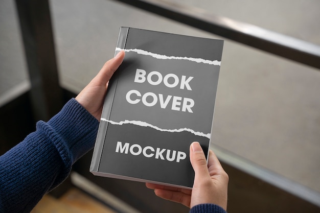 Person holding a book with mock-up cover