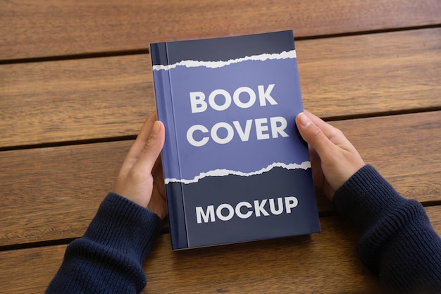 Person holding a book with mock-up cover