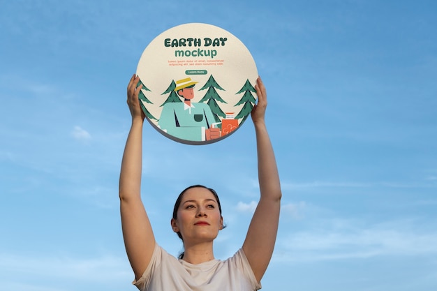 PSD person holding a signboard mockup for earth day