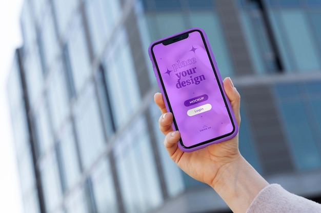 Person holding smartphone mock-up outdoors