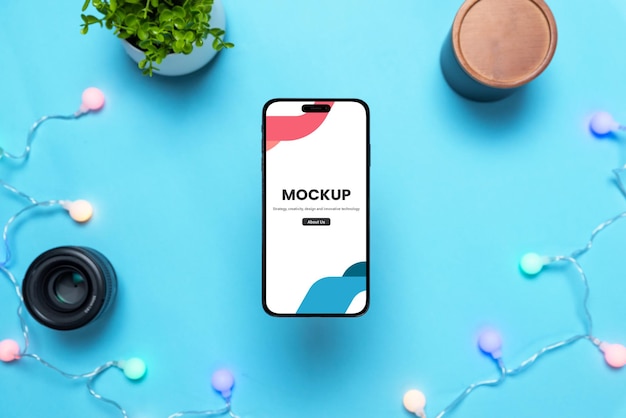 Phone mockup above blue table with holiday colorful light bulbs