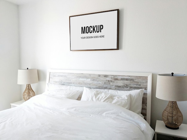 Picture frame in a bedroom above white bed