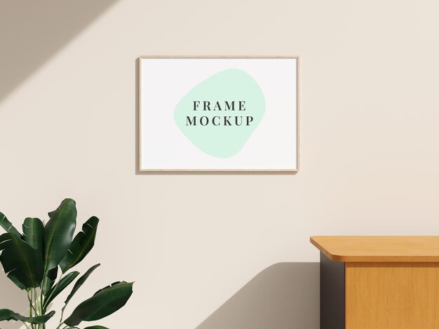 Picture frame mockup hanging on the wall with plant on minimalist interior