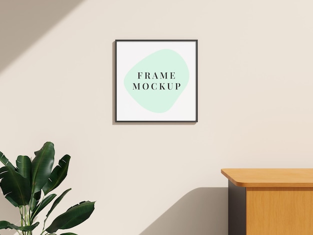 Picture frame mockup hanging on the wall with plant on minimalist interior