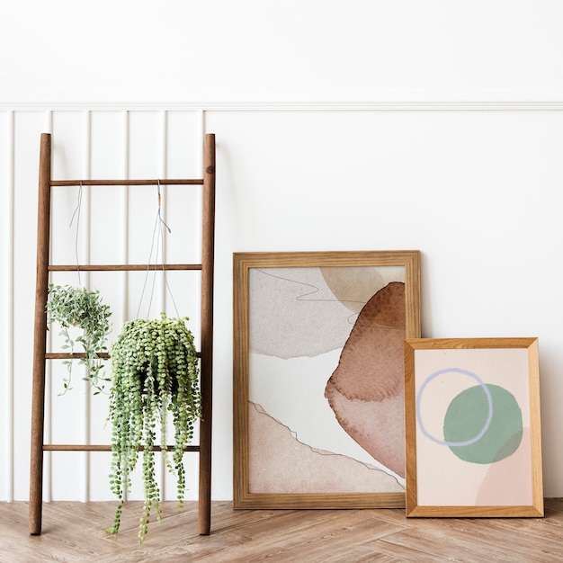 Plants hanging on a wooden ladder by picture frame mockups