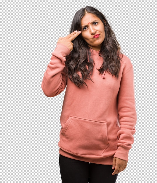 Portrait of fitness young indian woman making a suicide gesture, feeling sad and scared forming a gun with fingers