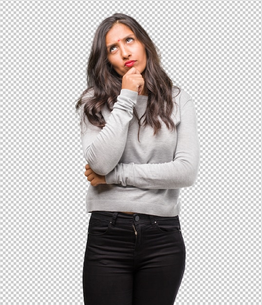 Portrait of young indian woman thinking and looking up, confused about an idea, would be trying to find a solution