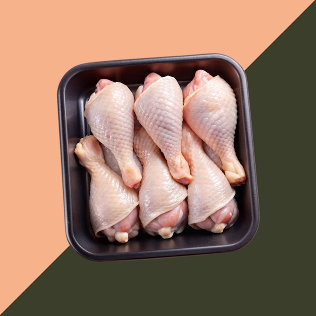 PSD of araw chicken legs in a black plastic tray isolated on transparent background