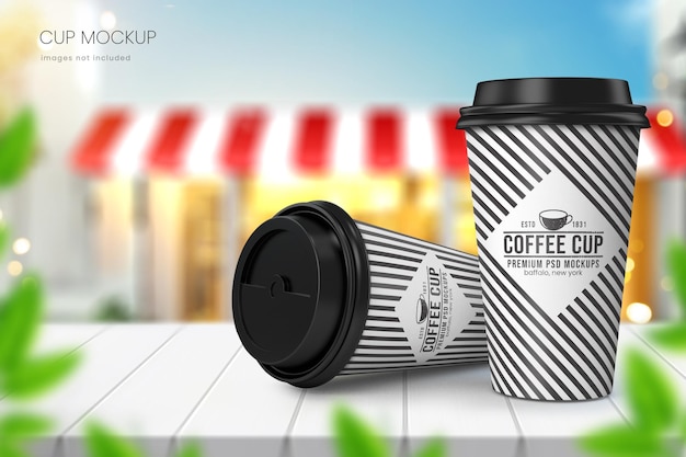 Realistic paper coffee cup mockup of two cups with blurred cafe and blue sky in background