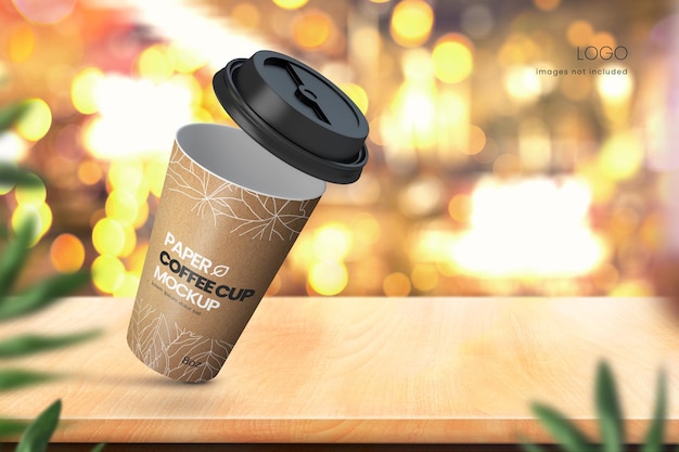 Realistic paper coffee cup mockup on wooden tabletop with bokeh lights in background