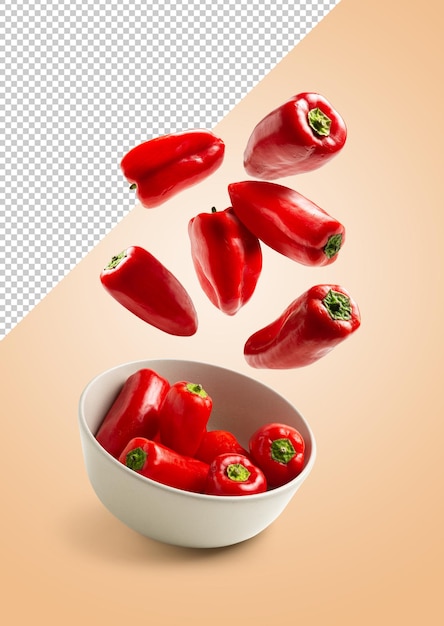 Red peppers falling into a bowl