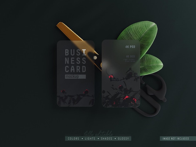 Rounded corner transparent business card mockup decorated with Scissor and leaves top view scene