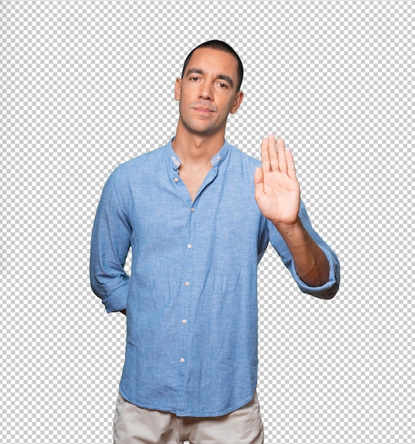 Serious young man making a gesture of stop with his palm