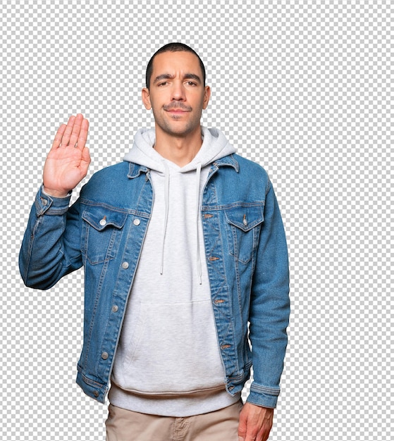 Serious young man making a gesture of stop with his palm