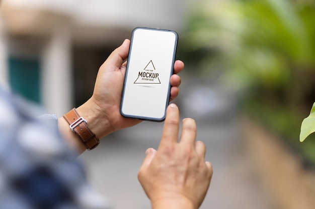 Over shoulder close up view of a man using smartphone mockup