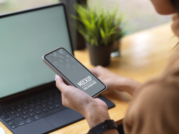 Side view of female holding smartphone mockup