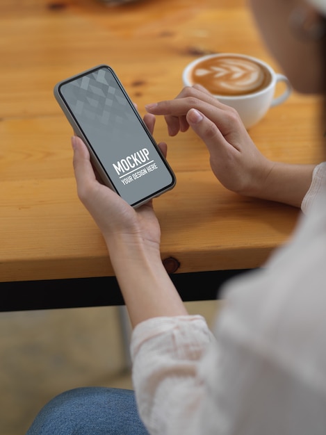 Side view of female holding smartphone mockup