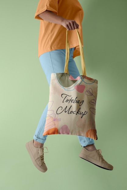 Side view of person holding tote bag mock-up