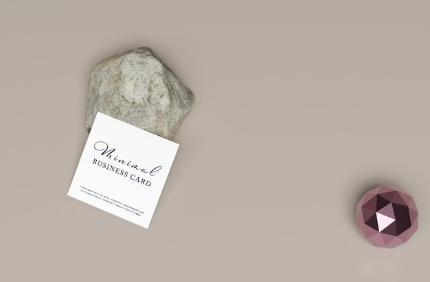 A small rock next to a small white sign that says international business card.