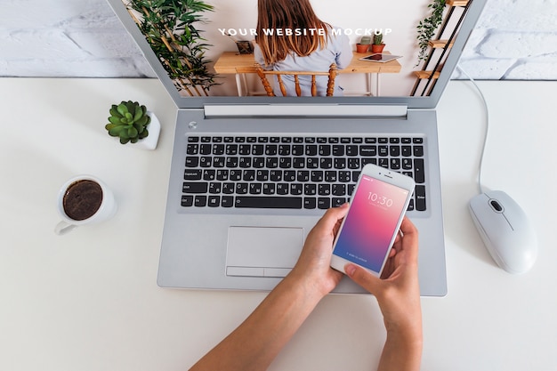 Smartphone mockup with laptop and workspace concept