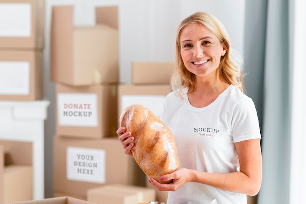 Smiley female volunteer holding bread for donation