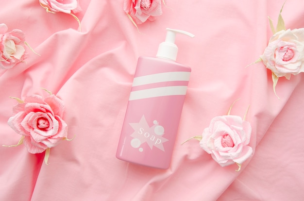 Soap bottle on pink fabric background