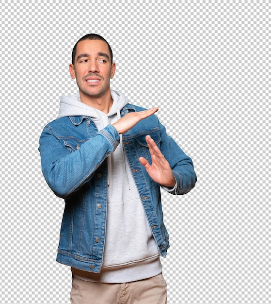 Stressed young man making a time out gesture with his hands