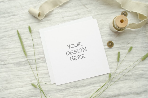 Summer stationery mockup ard for greeting card or wedding invitation with herbs, vintage spool of cotton braid on white