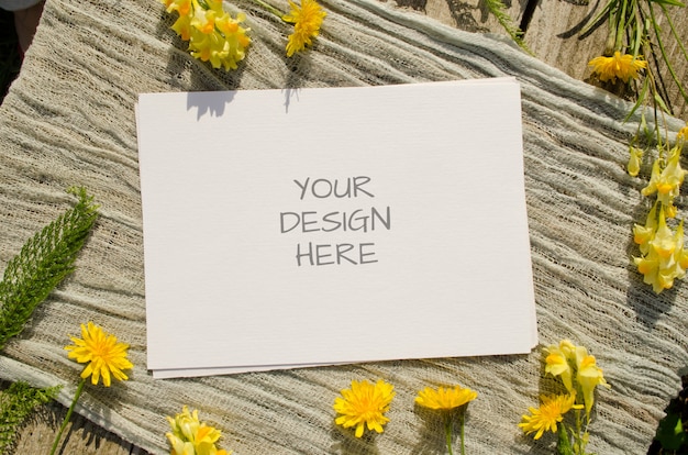 Summer stationery mockup greeting card or wedding invitation with yellow flowers on a old wood