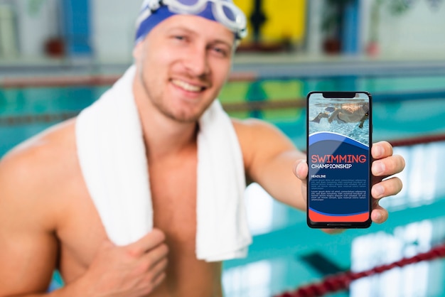 Swimmer in a pool house holding a mock-up mobile phone