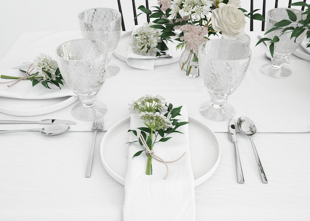 table prepared to eat with cutlery and decorative flowers