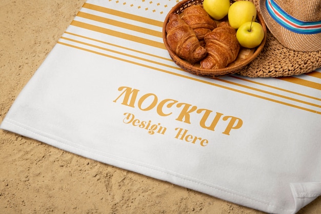 Tablecloth on beach sand with fruit and croissant