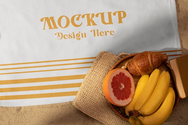 Tablecloth on beach sand with fruit and croissant