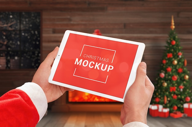 Tablet mockup in hands with Christmas decorations