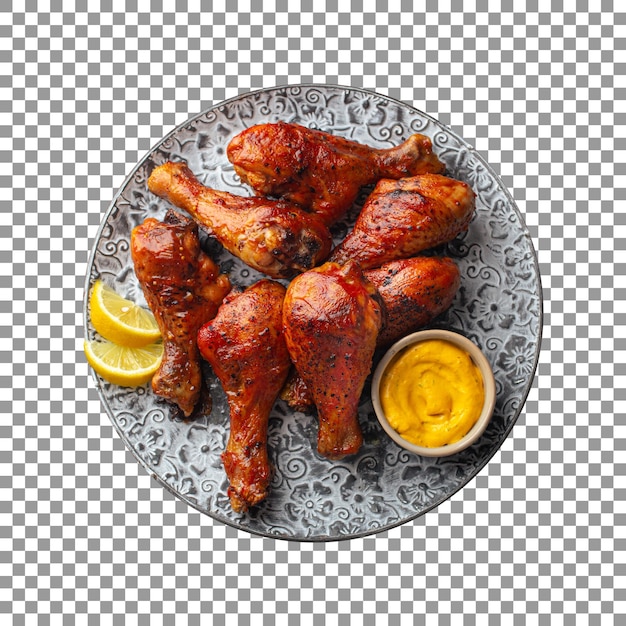 Tasty chicken tandoori legs with lemon wedges and a small bowl of sauce with transparent background