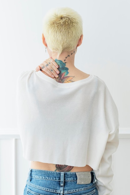 PSD tattooed woman in a white shirt mockup touching her neck