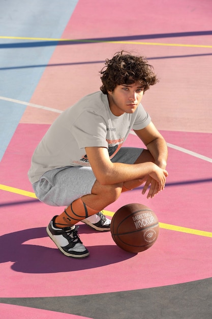 Teenage boy with basketball outside on the court