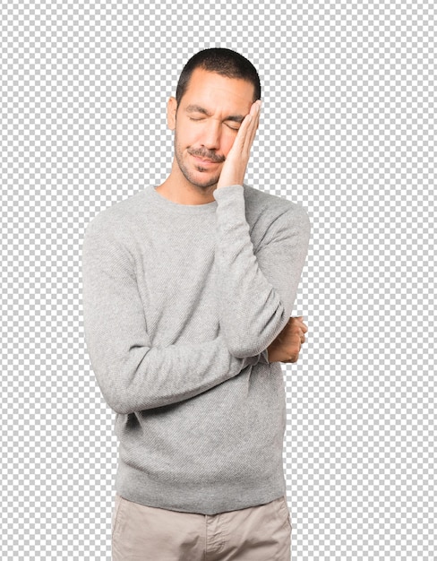 Tired young man posing against background