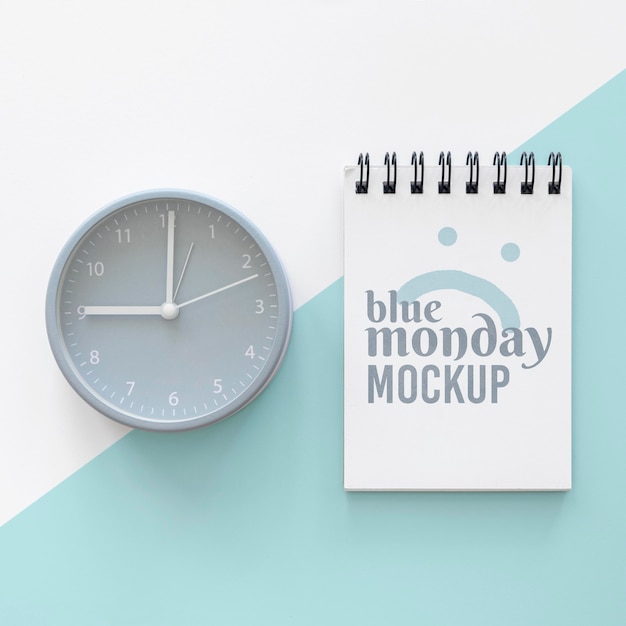 Top view of blue monday notebook with clock