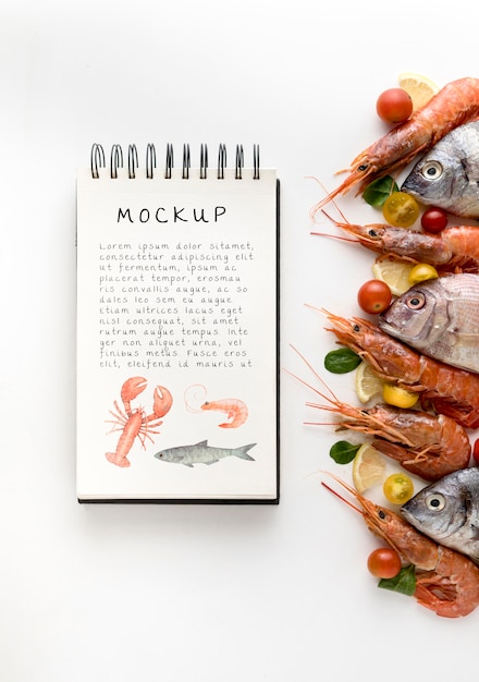 Top view of fish with shrimp and notebook