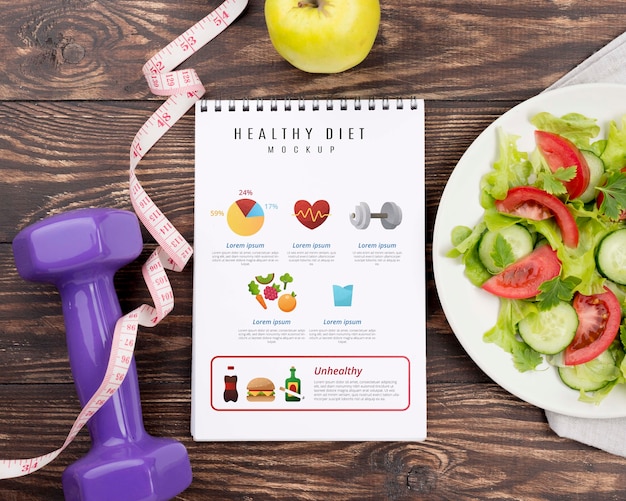 PSD top view of fitness notebook with plate of salad and measuring tape