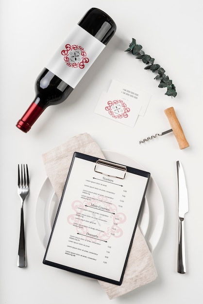 Top view of menu with wine bottle and cutlery