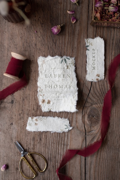 Top view of mock-up rustic paper wedding invitation with leaves and flowers