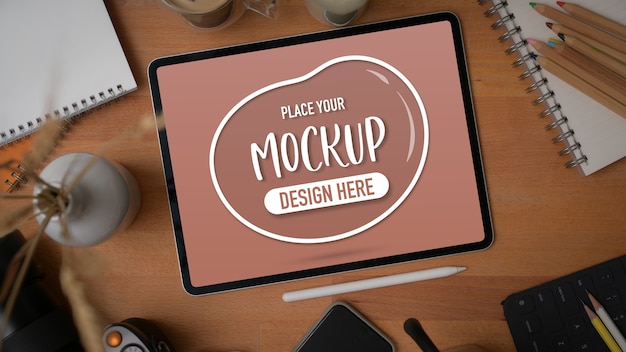 Top view of mockup digital tablet with stationery, supplies and decorations