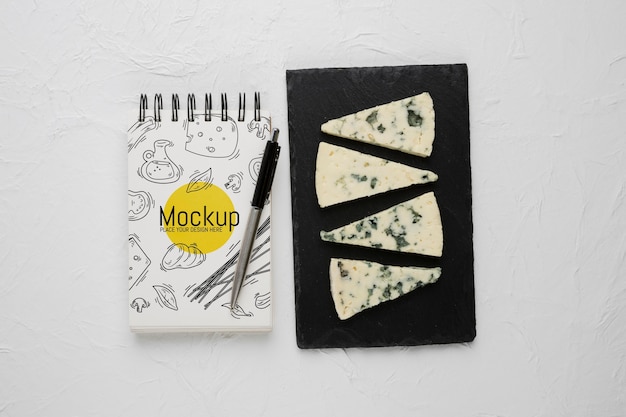 Top view of notebook and pen with moldy cheese