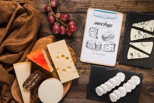 Top view of notepad with variety of cheese and grapes