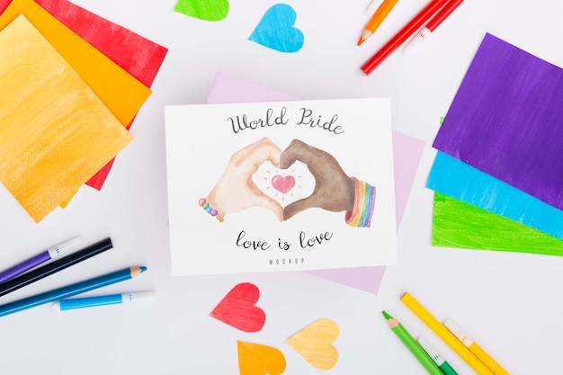 Top view of rainbow colored papers and hearts with pencils for lgbt pride